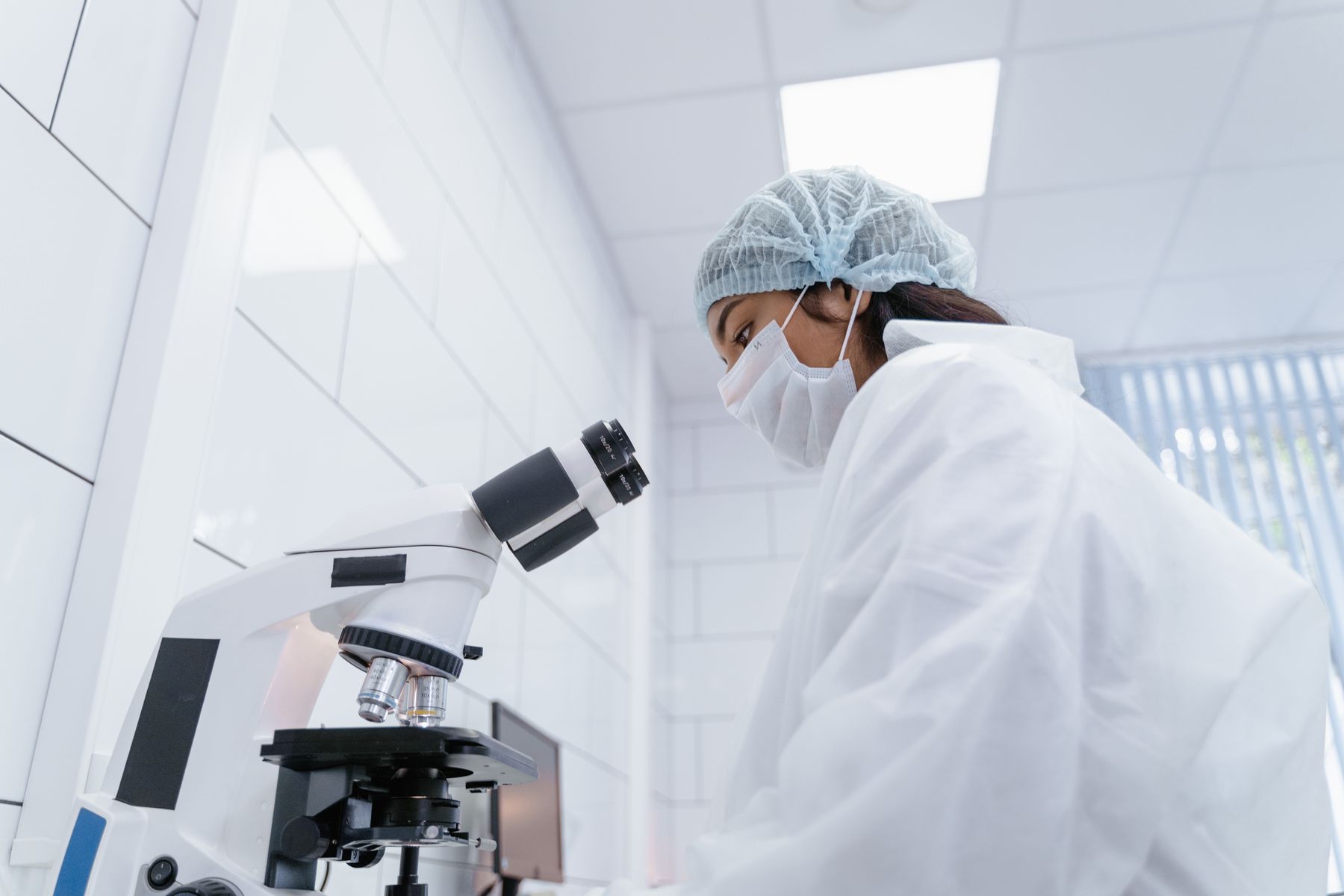 Researcher using a microscope in a laboratory.